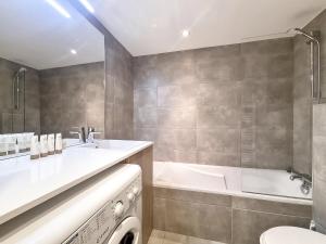 a bathroom with a tub and a sink and a toilet at La Bruyere - appartement - 6pers in Les Gets +20 photos