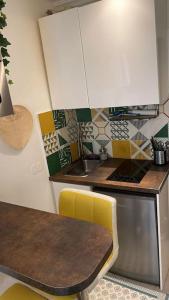 uma cozinha com um balcão, uma mesa e um lavatório em Charmant studio au Pecq / Saint-germain en laye. em Le Pecq