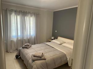 Deppys Apartment Porto Heli في بورتوخيلي: غرفة نوم عليها سرير وفوط
