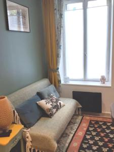 uma sala de estar com um sofá e uma janela em Charmant studio au Pecq / Saint-germain en laye. em Le Pecq