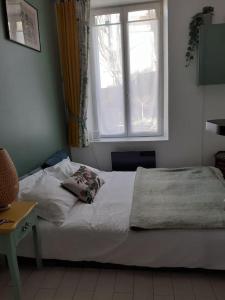 uma cama num quarto com uma janela em Charmant studio au Pecq / Saint-germain en laye. em Le Pecq