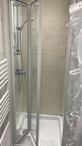 um chuveiro com uma porta de vidro na casa de banho em Charmant studio au Pecq / Saint-germain en laye. em Le Pecq