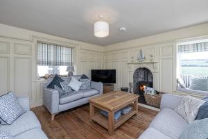 a living room with a couch and a fireplace at Cable Cottage in Llanrhyddlad