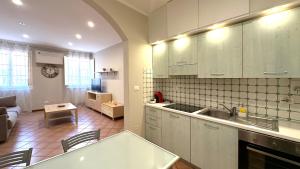 una cucina con mobili bianchi e un soggiorno di Int 8 - Suite Ginevra by Residence San Luca a Bologna