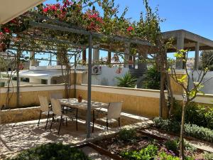 a patio with a table and chairs under a pergola at Deppys Apartment Porto Heli in Porto Heli