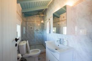 a bathroom with a sink and a toilet and a mirror at Anemomilos Sea View Penthouse in Corfu Town +14 photos