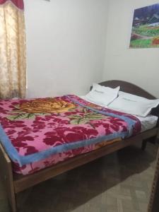 a bed sitting in a room with a purple blanket at Royal Queen Residency in Ooty