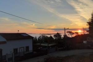 a view of a house with the sunset in the background at Casa Estrela in Alvaiázere