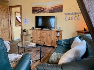 a living room with a couch and a tv at Haus Wildgans Ferienwohnung Rose in Behrensdorf