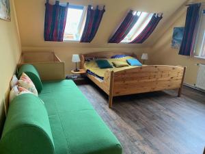 a bedroom with a bed and a couch and windows at Haus Wildgans Ferienwohnung Rose in Behrensdorf