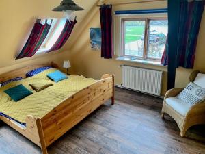 BehrensdorfにあるHaus Wildgans Ferienwohnung Roseのベッドルーム(大型木製ベッド1台、椅子付)