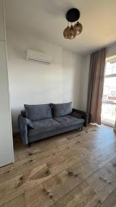 um sofá numa sala de estar com piso em madeira em CityCenterApartments-M32-8C em Bielsko-Biala