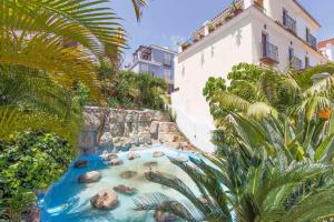 a river in front of a building with palm trees at Large townhouse Marbella golden mile in Marbella