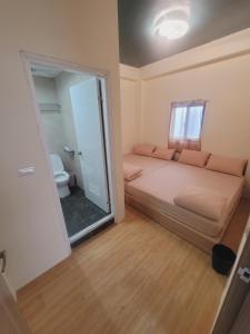 a small room with a bed and a bathroom at sky blue hostel in Lanyu