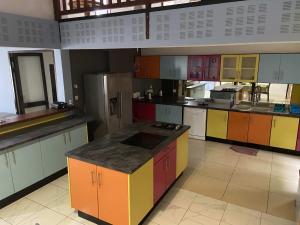 a large kitchen with colorful cabinets and appliances at Résidences Gamly in Mamoudzou