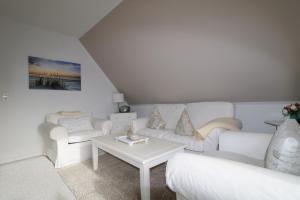 een woonkamer met een witte bank en een tafel bij Haus Bonken - a72764 in Wyk auf Föhr