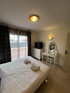 パルム・マールにある2 bedrooms apartement at Palm Mar 800 m away from the beach with sea view shared pool and furnished terraceのベッドルーム1室(白いベッド1台、タオル付)