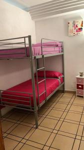 a room with two bunk beds with red sheets at 3 bedrooms villa with private pool enclosed garden and wifi at Valencia in Marchuquera