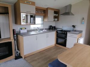 a small kitchen with a sink and a stove at Ivy cottage - Parking and outdoor area in Kent