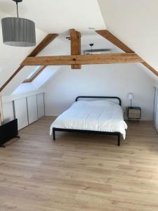 a bedroom with a large bed in a attic at « La Suisse » Courcelloise in Courcelles-Sapicourt