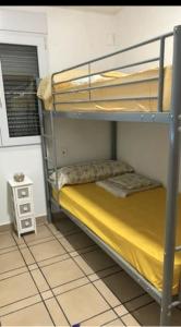 a bunk bed in a room with a yellow bedsheet at 3 bedrooms villa with private pool enclosed garden and wifi at Valencia in Marchuquera