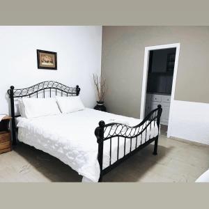um quarto com uma cama grande e lençóis brancos em VILLA MARIA (2) em Liapades