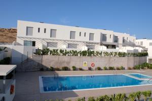 a building with a swimming pool in front of a building at Casa Mara Médano in El Médano