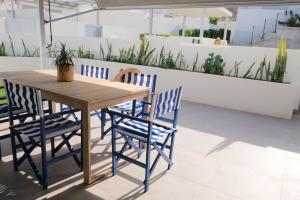 a wooden table with four blue chairs around it at Casa Mara Médano in El Médano