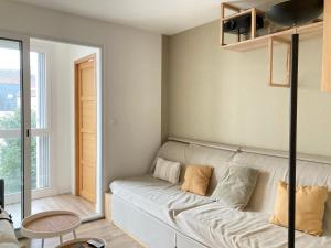 uma sala de estar com um sofá e uma janela em La Grande Coloc - Superbe T4 refait à neuf em Poitiers