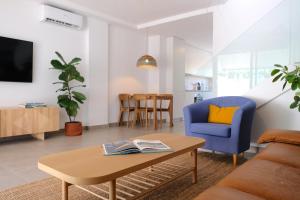 a living room with a table and a blue chair at Casa Mara Médano in El Médano