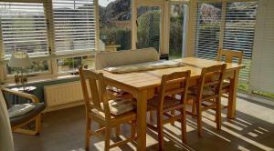 a kitchen with a wooden table and chairs and windows at 405 Tigh Bhrendain Renvyle in Renvyle +17 photos