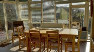 comedor con mesa, sillas y ventanas en 405 Tigh Bhrendain Renvyle, en Renvyle