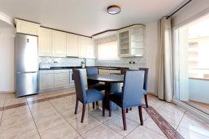 a kitchen with a table and chairs and a refrigerator at Apartamentos Empuriabrava Maurici Park in Empuriabrava