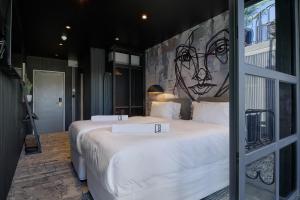 Cargo88 Hotel في لوساكا: غرفة نوم بسريرين مع لوحة على الحائط