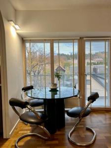 une table et des chaises dans une chambre avec une grande fenêtre dans l'établissement New appartment with art collection, à Vilnius
