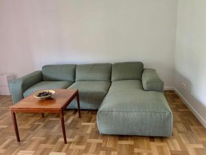 a green couch in a living room with a table at New appartment with art collection in Vilnius