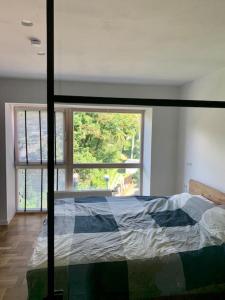 um quarto com uma cama e uma grande janela em New appartment with art collection em Vilnius