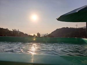 ein Boot im Wasser mit einem Regenschirm in der Unterkunft Seaview Eagles Nest Apartments in Rawai Beach