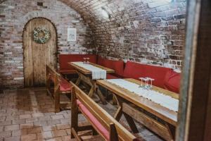 a dining room with wooden tables and red benches at penzion V Růžích in Hroznová Lhota +1 photo