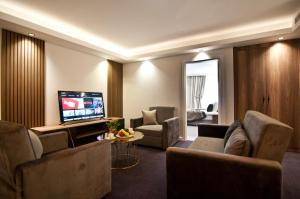 Il comprend un salon avec des canapés et une télévision à écran plat. dans l'établissement VALİDE RESİDENCE, à Istanbul