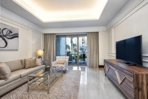 uma sala de estar com um sofá e uma televisão de ecrã plano em Town house residency 2 em Doha