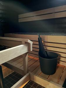 a black pot sitting next to a wooden bench at Modern & Stylish 2BR Apartment with Sauna, Terrace and Free Private Parking in Lahti