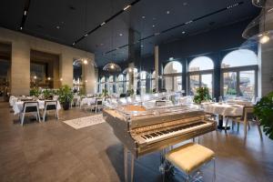 um restaurante com um piano no meio de uma sala em Town house residency 2 em Doha