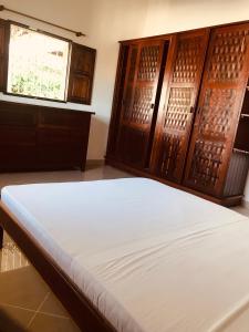 um quarto com uma cama e armários de madeira em Villa hafaliana em Nosy-Be