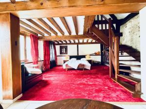 a large room with a bed and a staircase at LIAGE - La Maison qui relie in Saint-Marcel