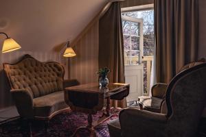 a living room with a table and chairs and a window at Best Western Strand Hotel in Visby