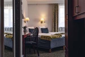 een hotelkamer met een bed, een bureau en een stoel bij Best Western Strand Hotel in Visby