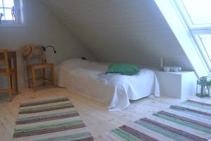 ein Schlafzimmer mit einem Bett im Dachgeschoss in der Unterkunft Loft Apartment at Isola Gård on the middle of Öland in Färjestaden