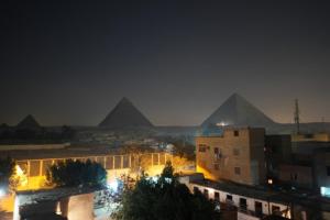 una vista de las pirámides de Giba por la noche en New Tut pyramids hotel, en El Cairo