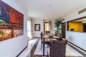 a dining room with a large painting on the wall at Royal Beach Residence in Dubai